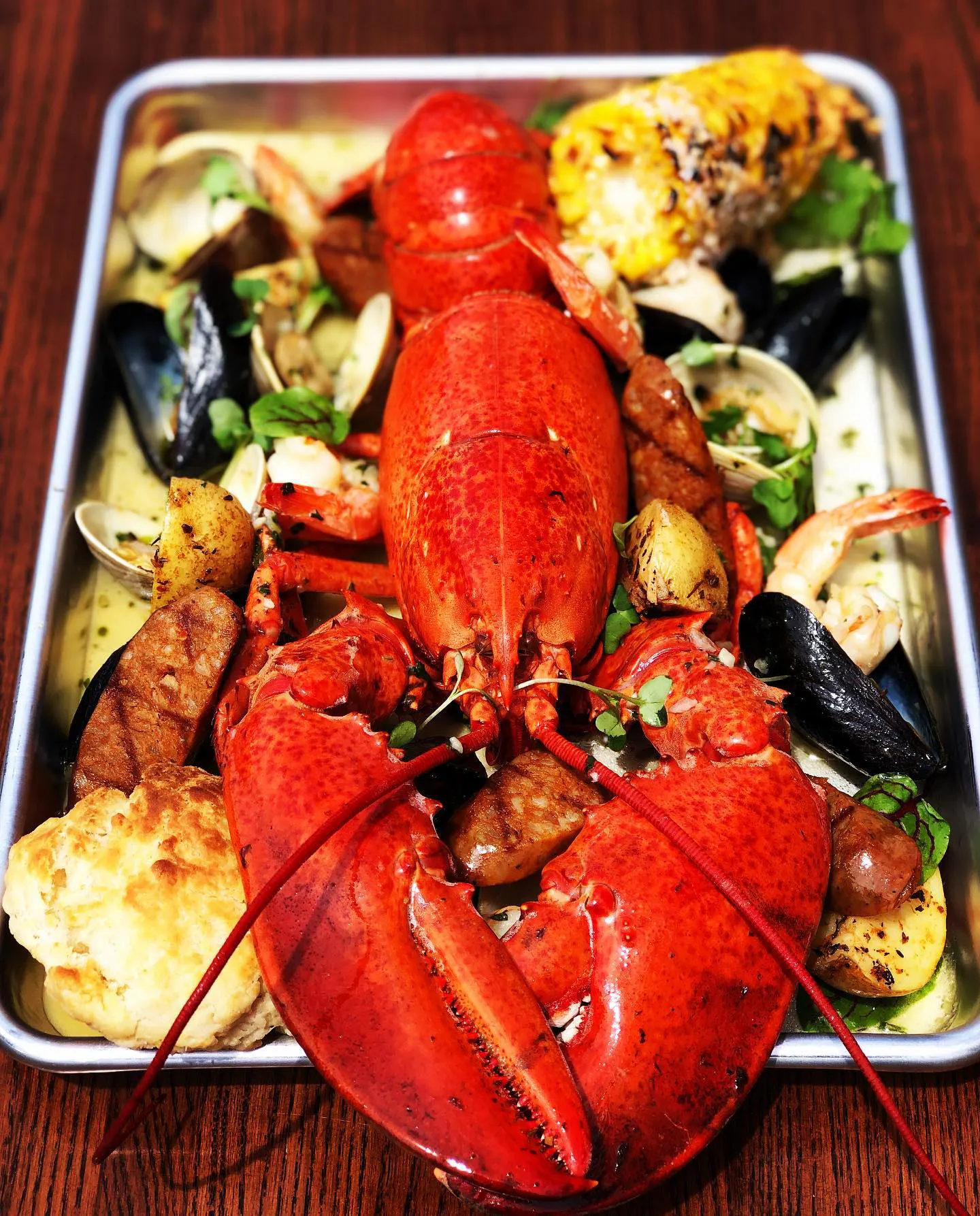baked lobster entree with vegetables, mussels & clams